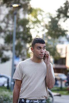Young Indigenous Australian man talking on mobile phone outdoors