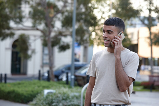 Young Indigenous Australian man talking on mobile phone outdoors