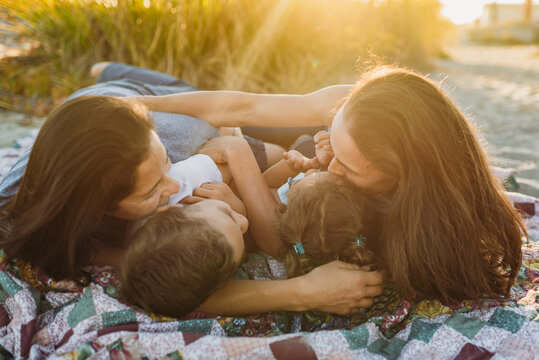 Lesbian wives on beach blanket with children 