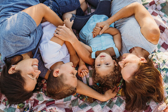 Same sex parents and kids lying on blanket