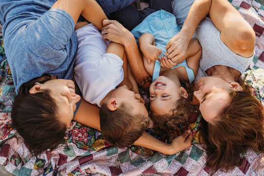 Happy family with two moms lying on blanket