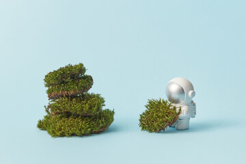 Toy astronaut stacking pieces of moss
