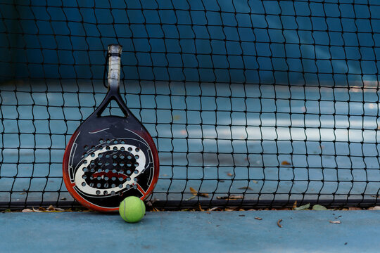 Padel racket and a ball on the court