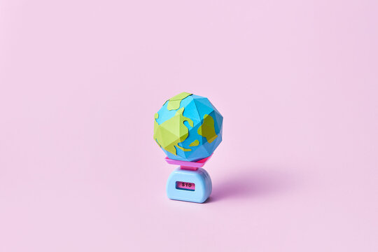 Earth globe on scales with price sign