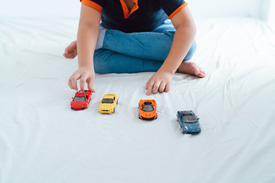 Little boy playing with toy car in door