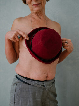Senior female cover breasts hat torso smile