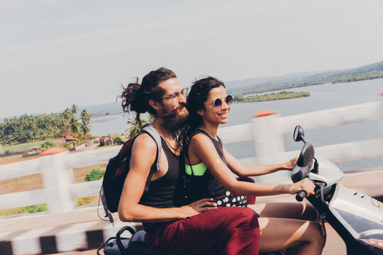 Couple riding on scooter through the bridge in Asia