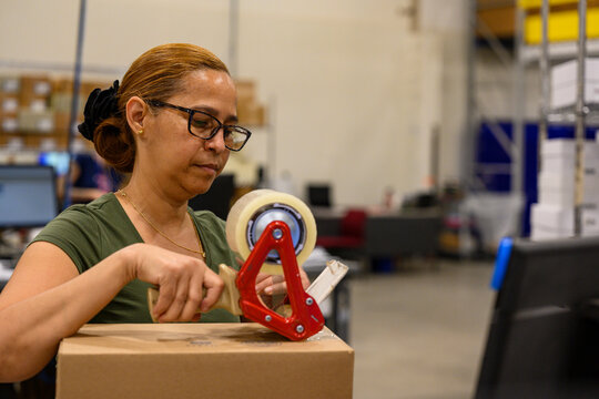 E-Commerce warehouse worker taping box