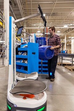 Blue collar worker at Warehouse with robot 