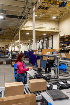 Online shipping warehouse worker with computer 