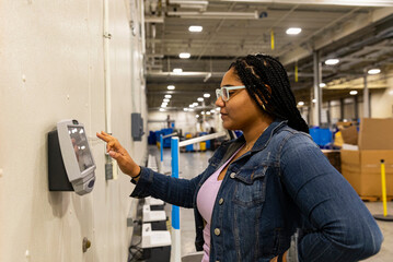 Hispanic worker with glasses punching time clock 