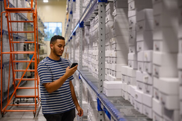worker looking at mobile device inventory aisle