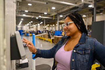 Industrial worker checking in with time clock 