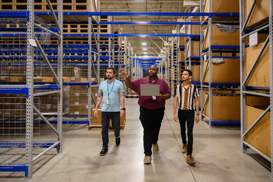 Manager leading meeting with trainees in warehouse 