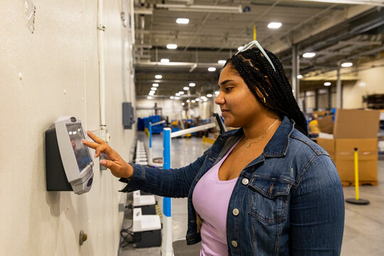 Hispanic worker checking in with time clock 