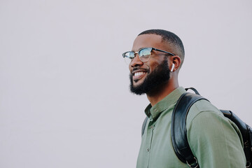 Bearded man with glasses and ear buds. 