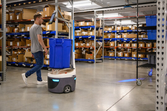 Manager with digital Robot on floor at Warehouse 