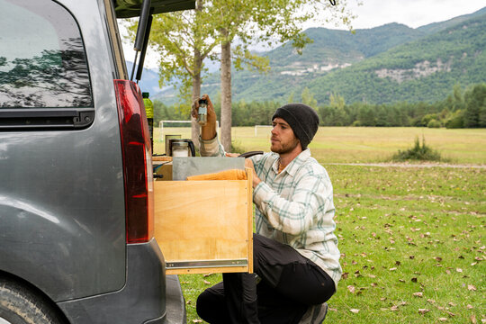Man preparing lunch at the back of camper van