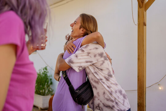 Teen friends hugging at house party