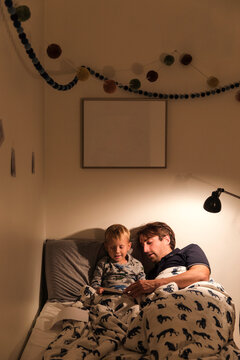 Father reading to a little boy in bed