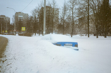 Blue car on the side of the road next to traffic signs 