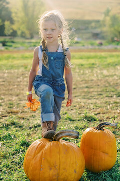 farm girl with foot on pumpkin