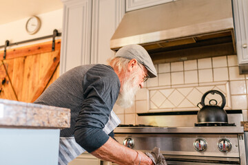 Senior man opening oven 