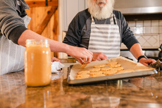 Teen boy making peanut butter cookies with his grandpa
