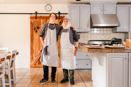 Proud Family men in aprons at modern farmhouse kitchen