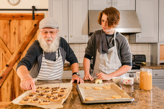 Teenager and grandpa counting baked cookies