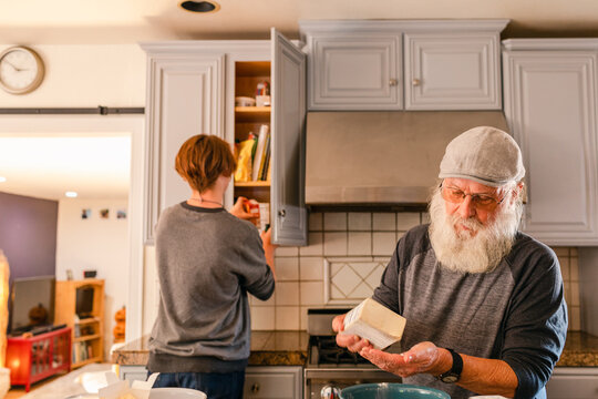 Grandson and grandfather making cookie mass