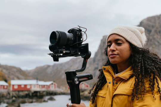 Focused photographer shooting video in countryside