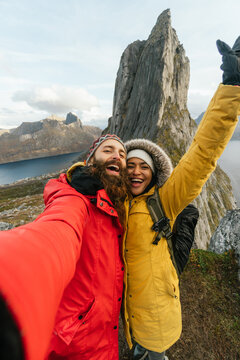Cheerful travelers taking selfie in mountains