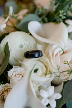 Closeup of a Groom's Ring Sitting on Flowers