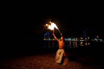 tribal latino man conducts a fire show