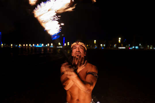fire show performer twists a fire rod 