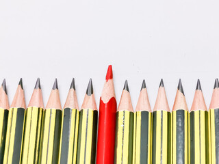 Leadership concept. Red pencil standing out from crowd of black pencils.