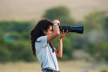 Arab woman taking photo in savanna