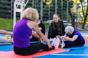 Coach explaining to women about seated forward bend