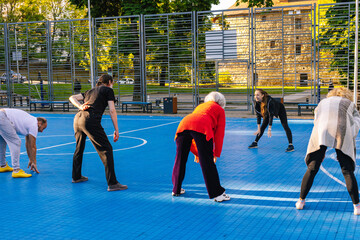 Female Coach demonstrating exercises to elder persons