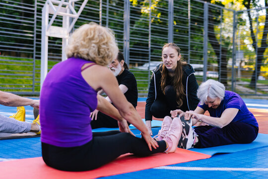Coach explaining to women about seated forward bend