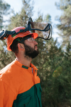 Serious woodcutter in uniform in woods
