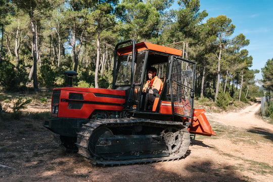 Man working on tractor in forest