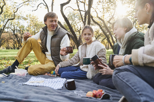 Family sharing hot drink during picnic