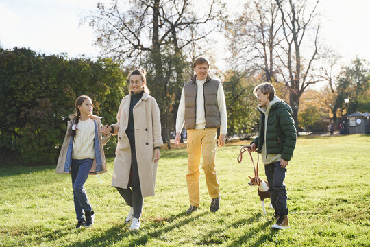 Family with dog walking in park