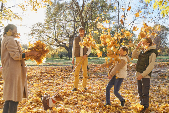 Family playing with autumn leaves