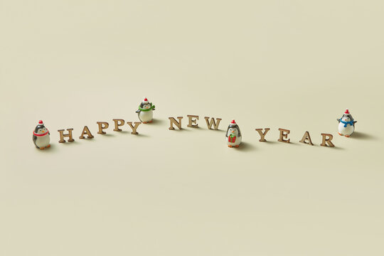 Happy new year message with penguins statuettes - Powered by Adobe