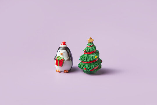 Figure of penguin with gift near christmas tree