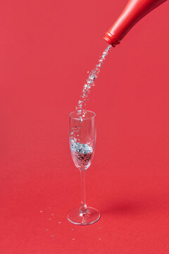 Glitter pouring from bottle into glass