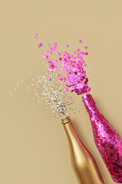 Decorated bottles of champagne splashing with confetti